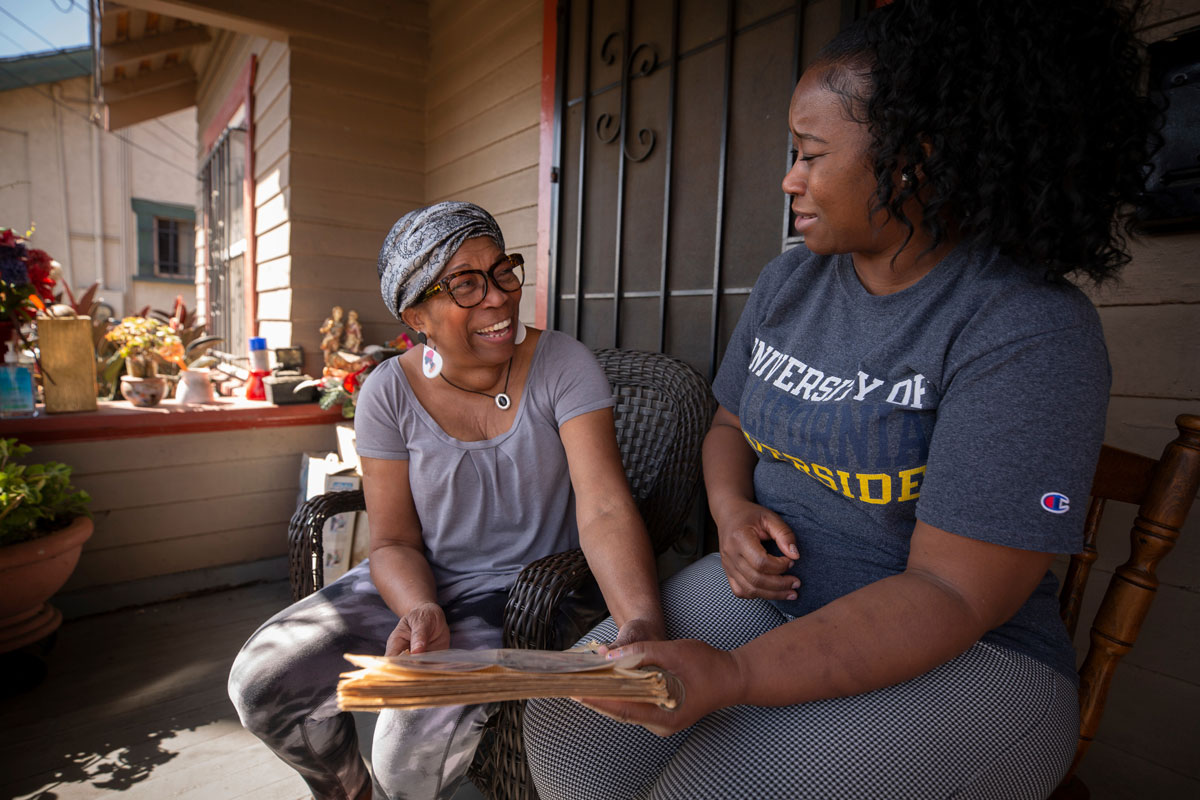 Deidre Reyes looking at pictures with her mom on the porch