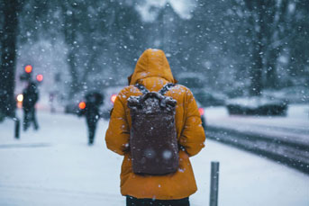 Man in jacket walking through snow