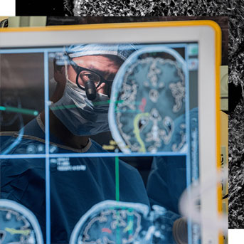 Eddie Chang reflected in a screen showing activity in the brain during surgery