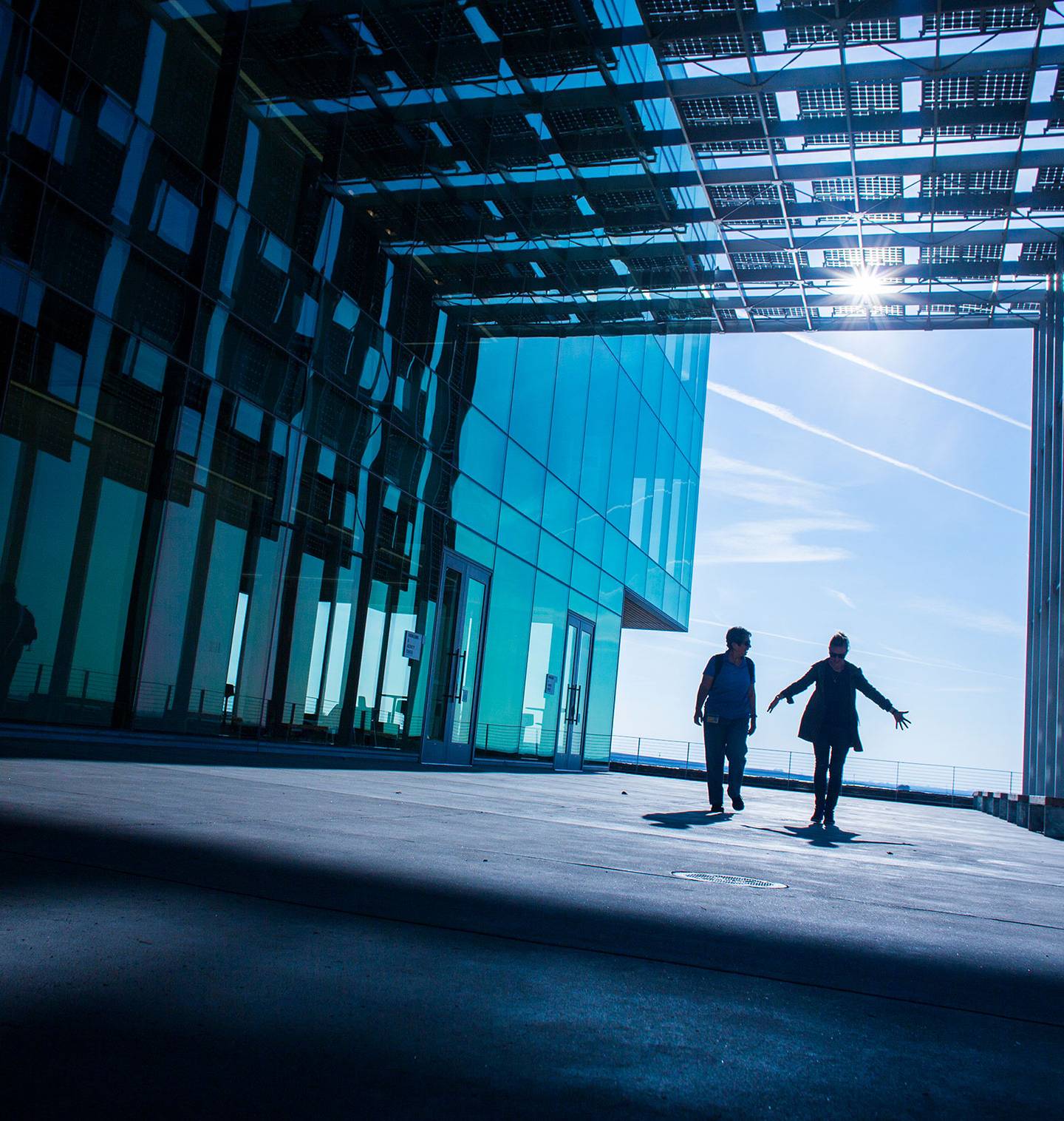 Two people walking through a solar-powered building