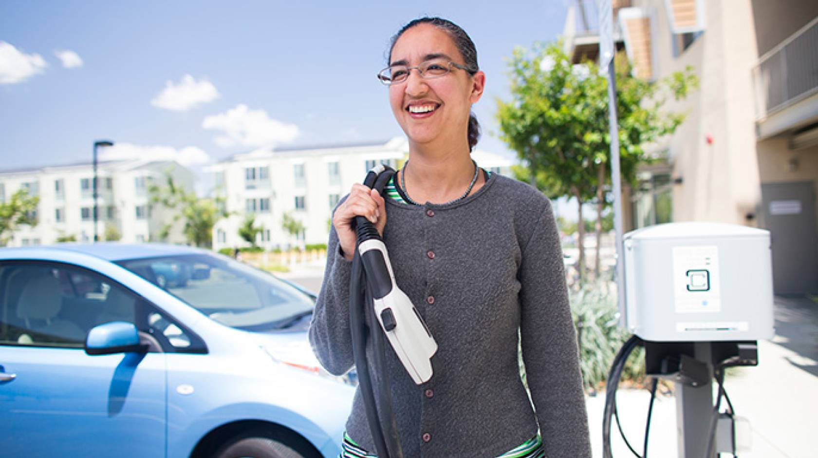 Dahlia Garas plugging in her electric vehicle at UC Davis' West Village