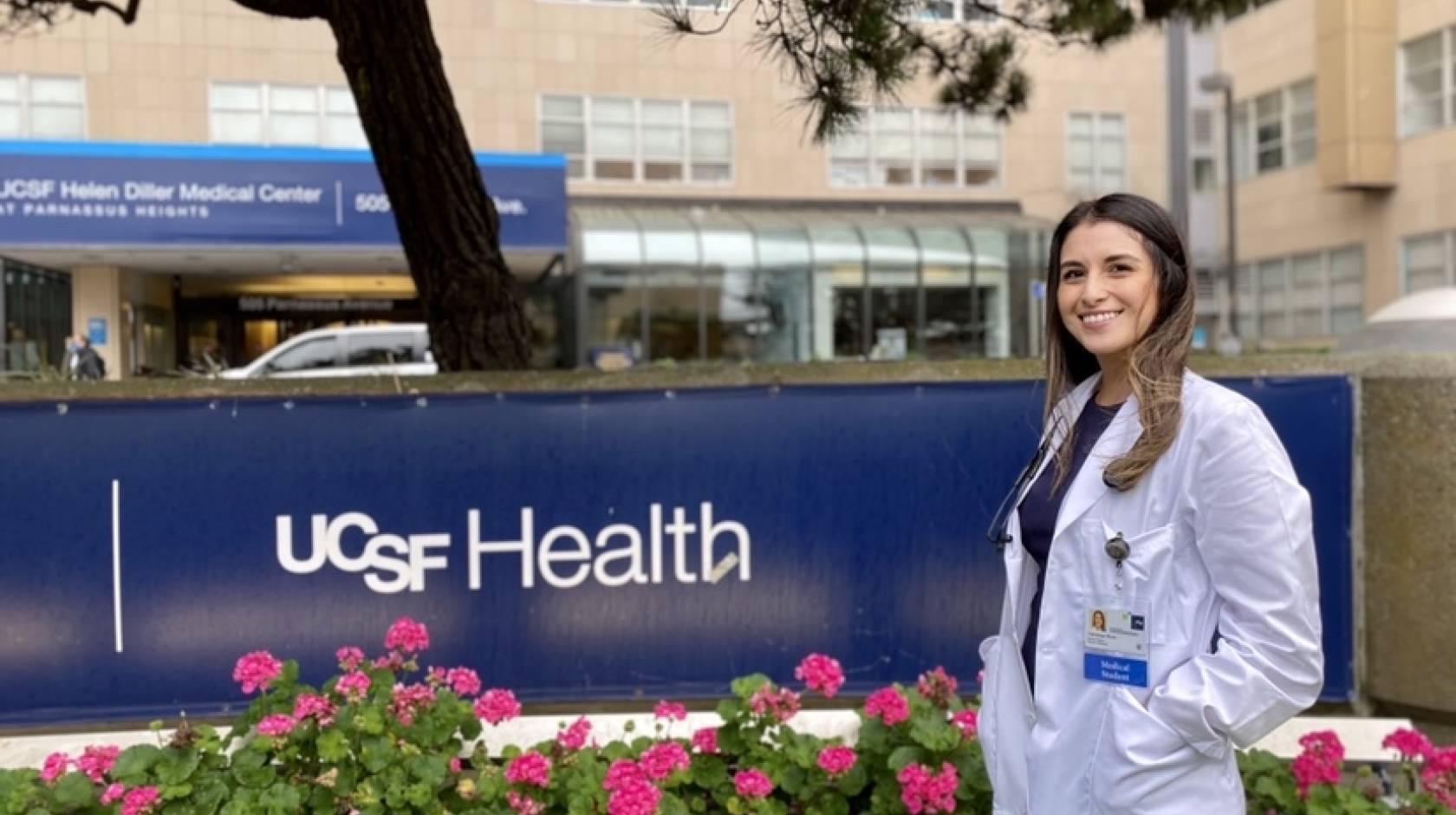 Vanessa Mora in a white coat in front of UCSF Health sign