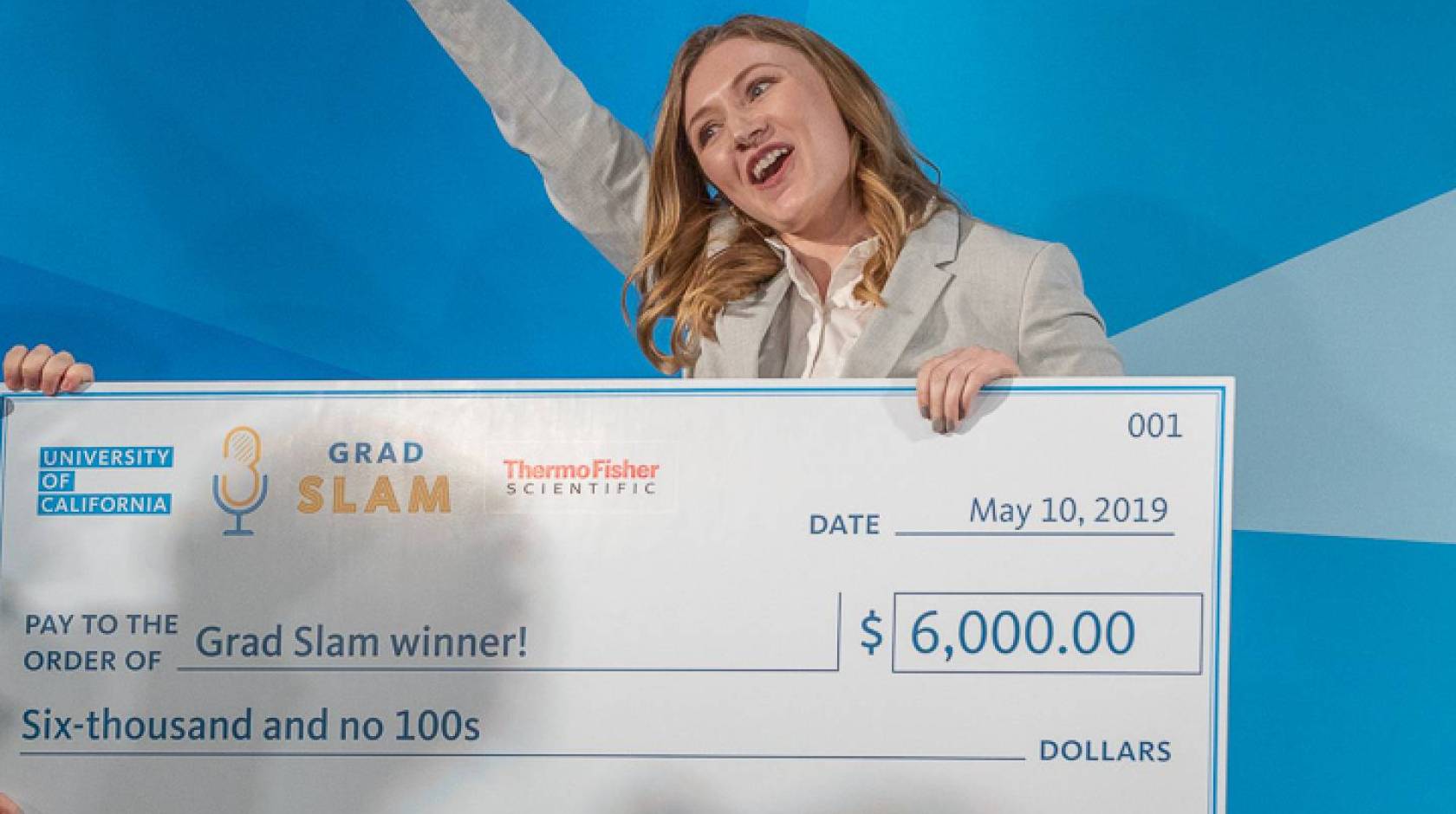 2019 Grad Slam winner Katie Murphy cheers with her trophy and giant check