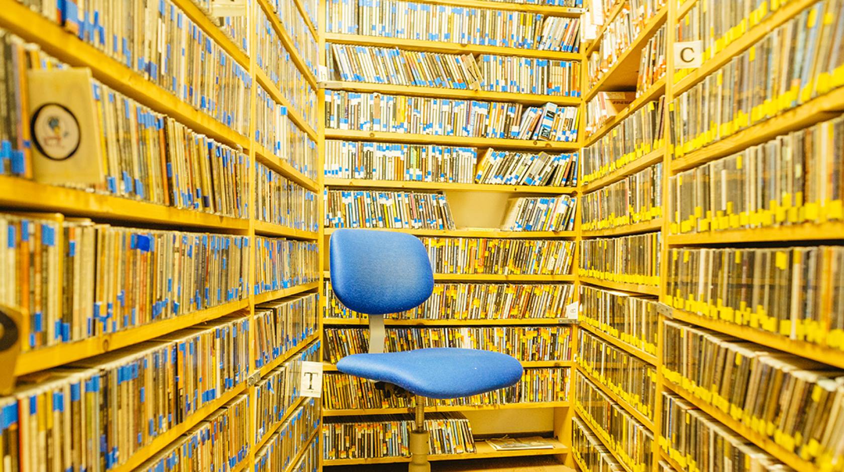 Library stacks and a blue chair