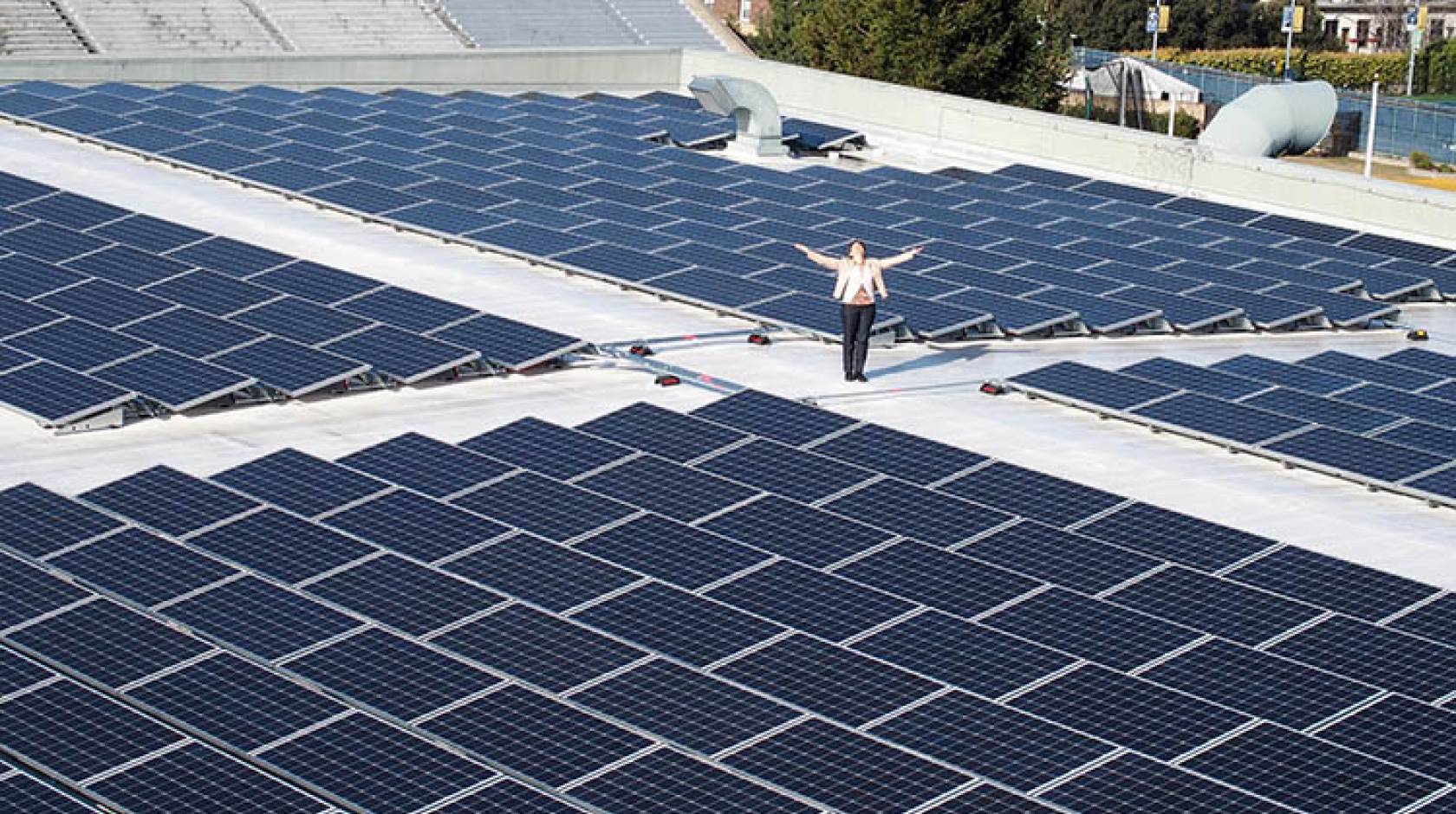 Kira Stoll, UC Berkeley's director of sustainability stands with solar panels on the top of the Recreational Sports Facility. 