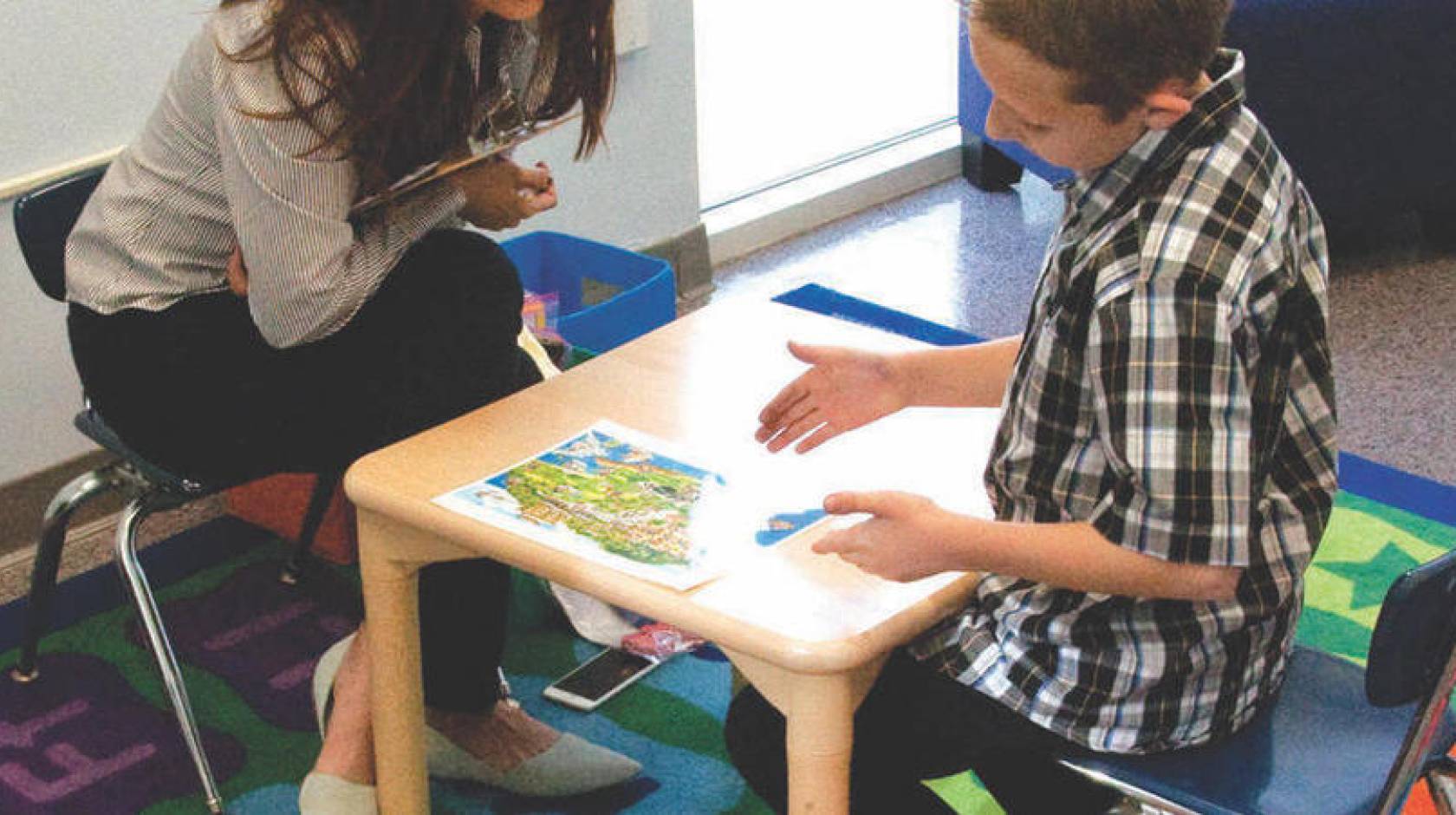 A UC Riverside SEARCH Center staffer works with an autistic child