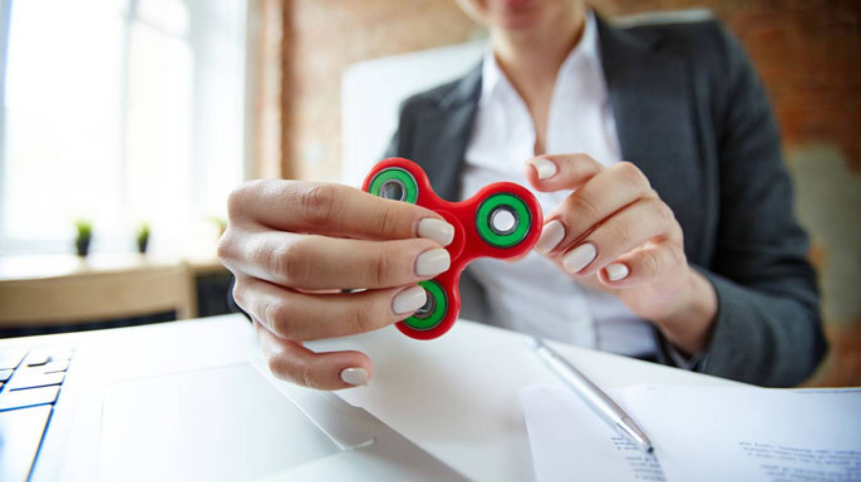 Woman in office playing with fidget spinner