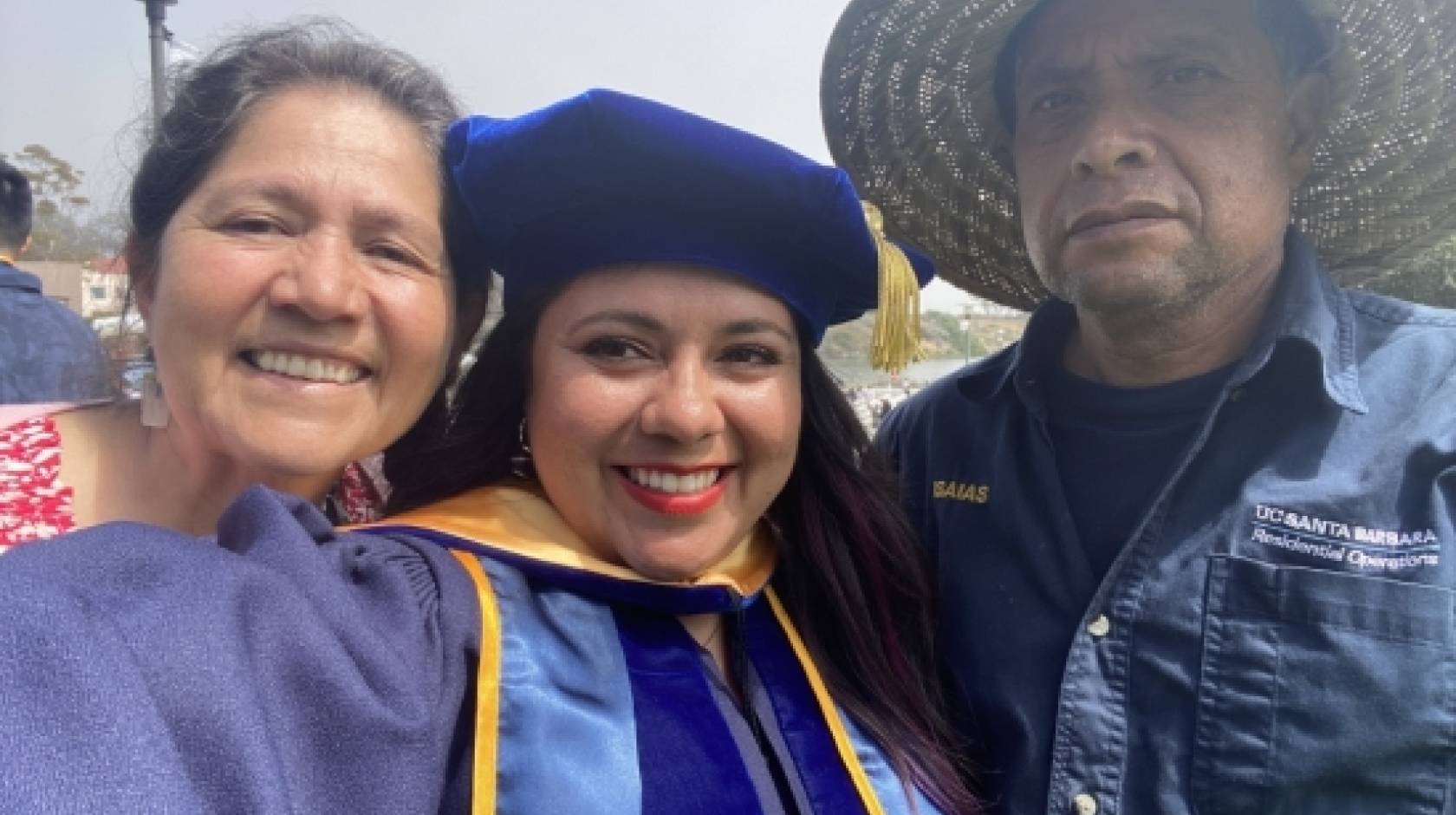 Dr. Ana Y. Guerrero in cap and gown with her parents, a selfie