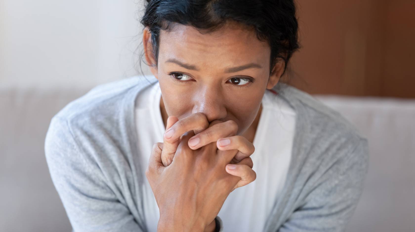 Pensive African American young woman looking in distance thinking pondering