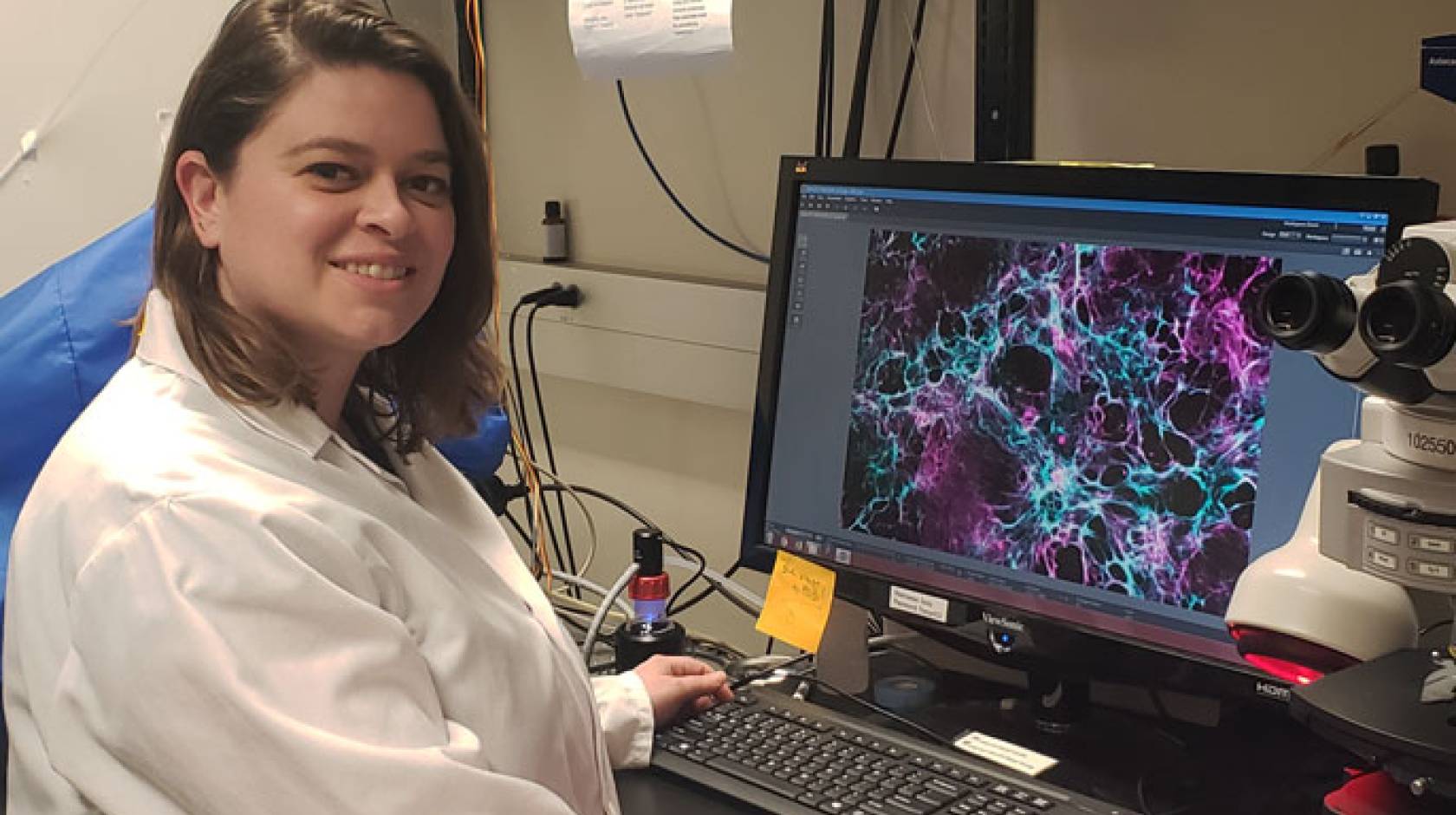 Ariel Krauss sitting in front of a computer with an image of a heart