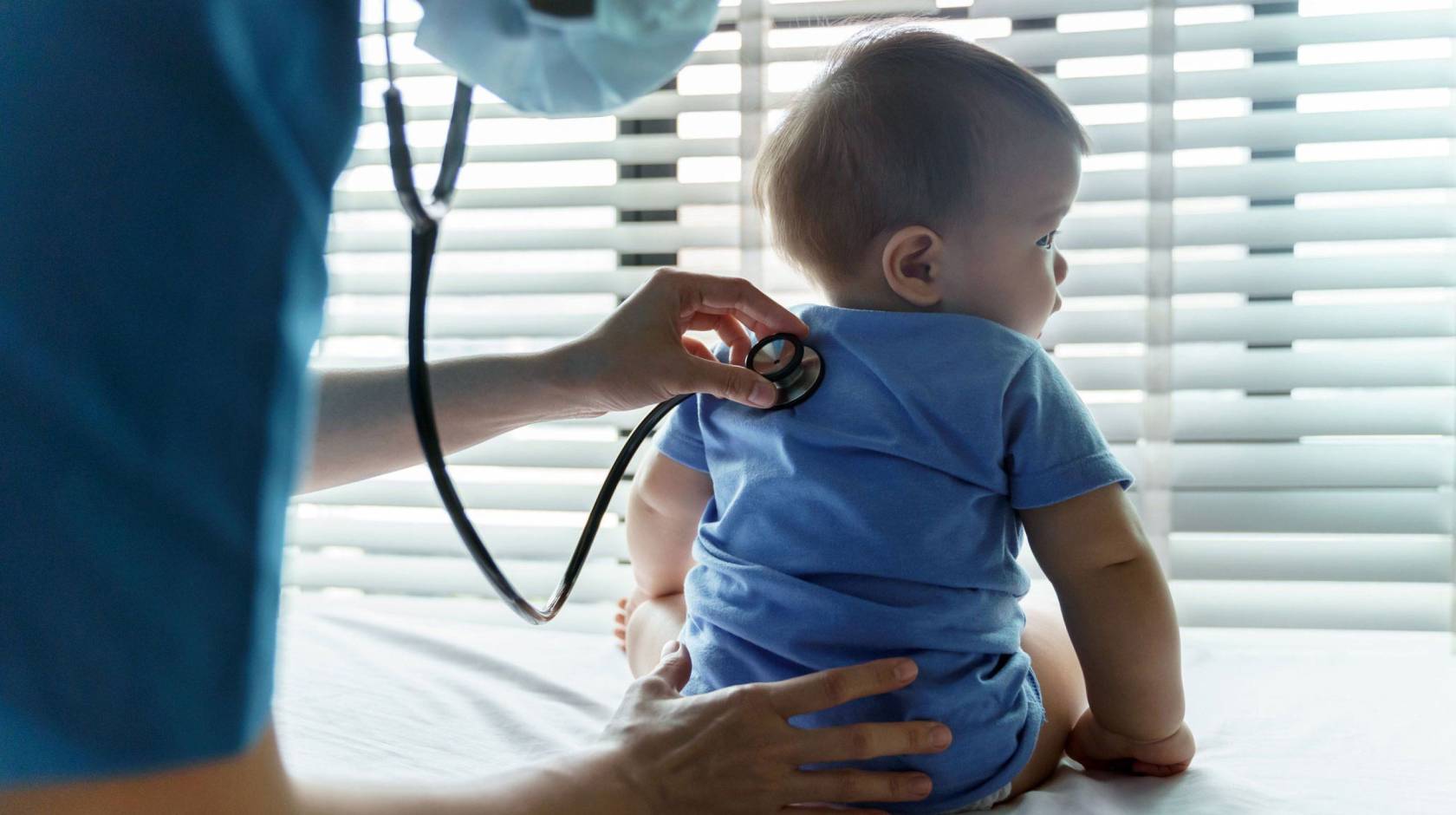 An infant getting checked by a pediatrician with a stethoscope