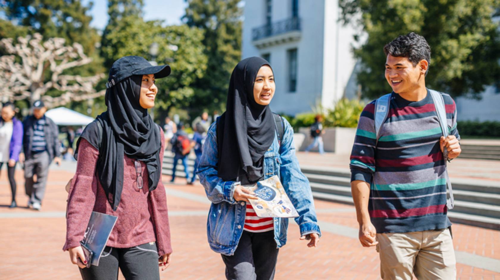 A boy walks next to two fellow students in hijabs on the Berkeley campus