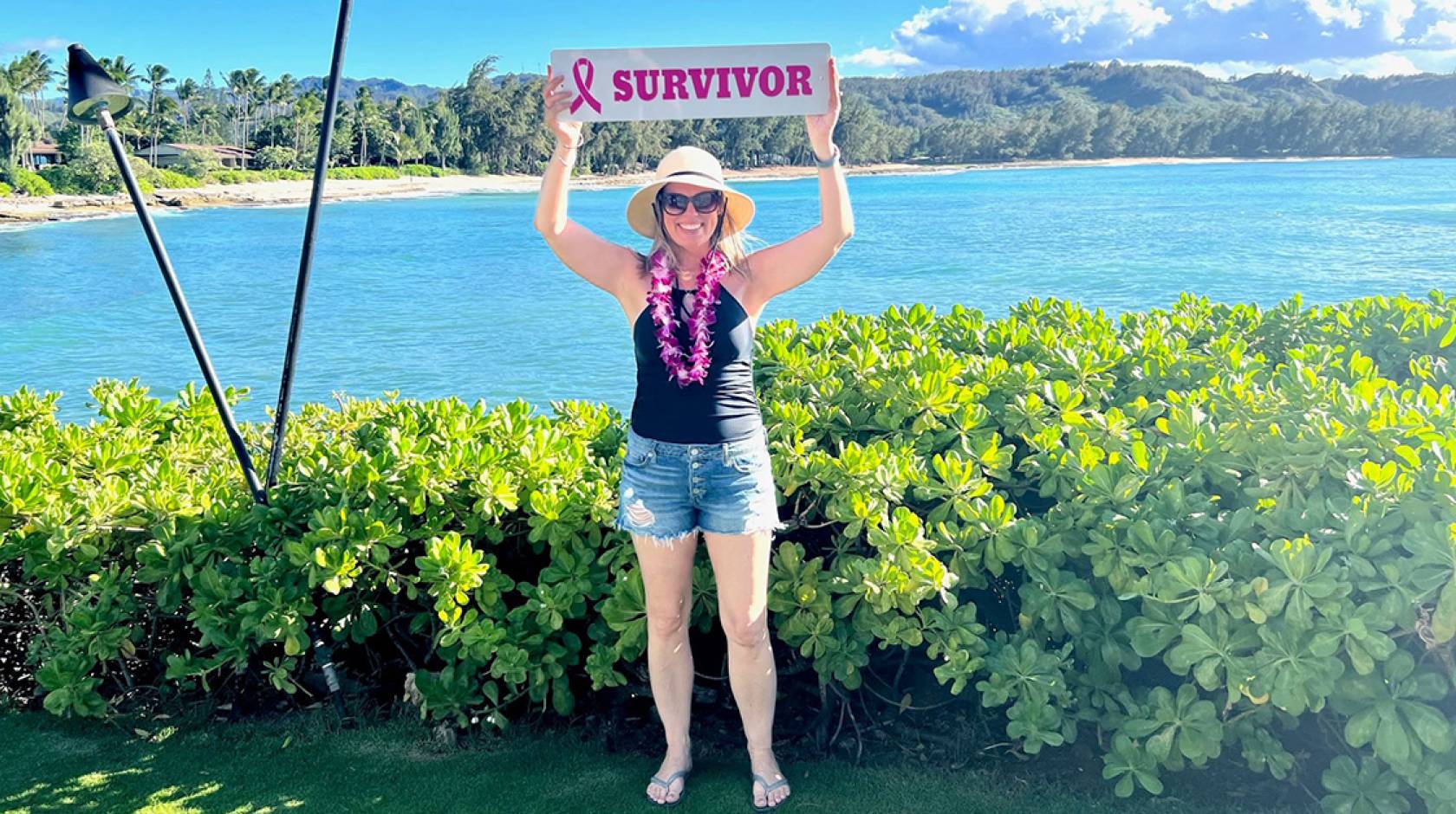 Michelle Brubaker holding up a survivor sign in Hawaii