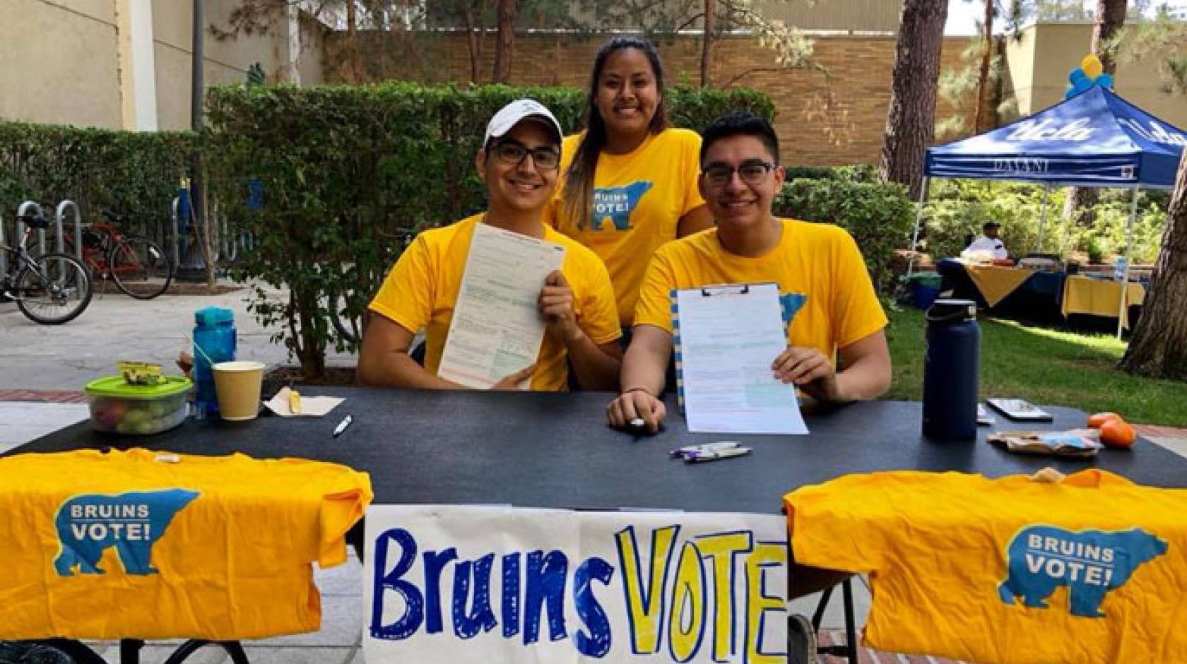 Three UCLA students registering voters at a table