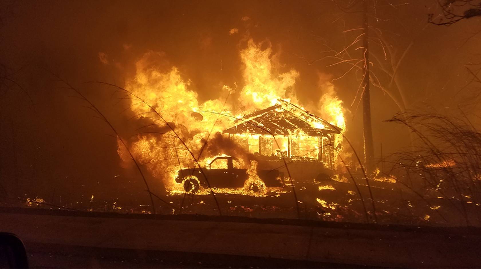 House and a truck on fire during the Camp Fire