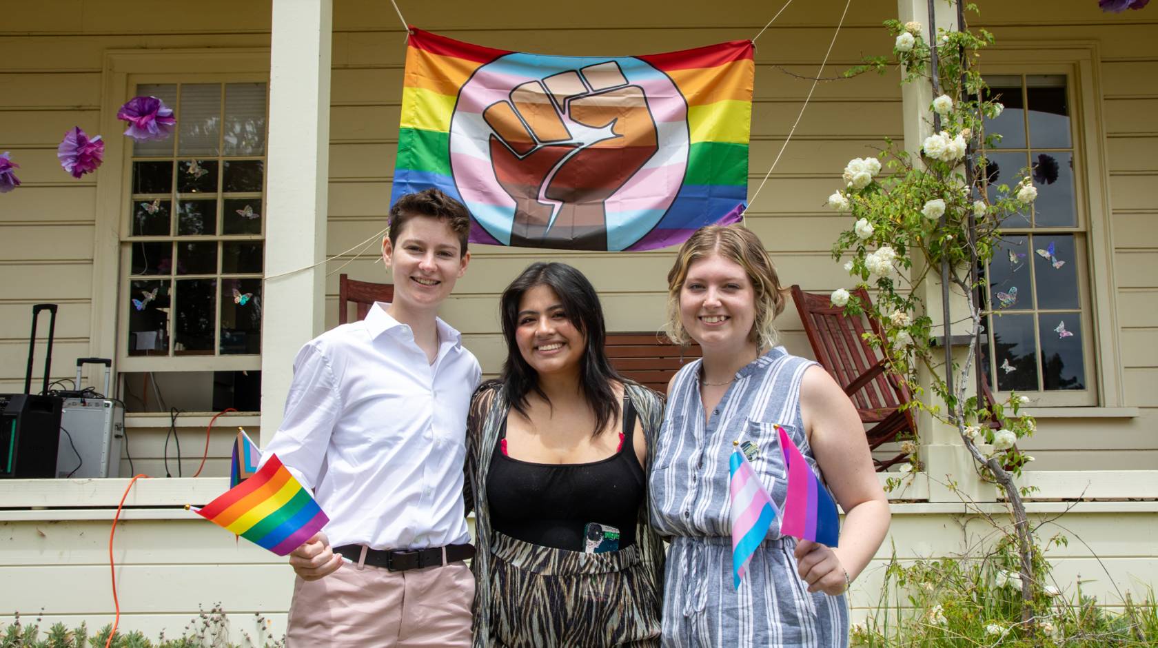 Three people in front of Lionel Cantú Queer Resource Center porch