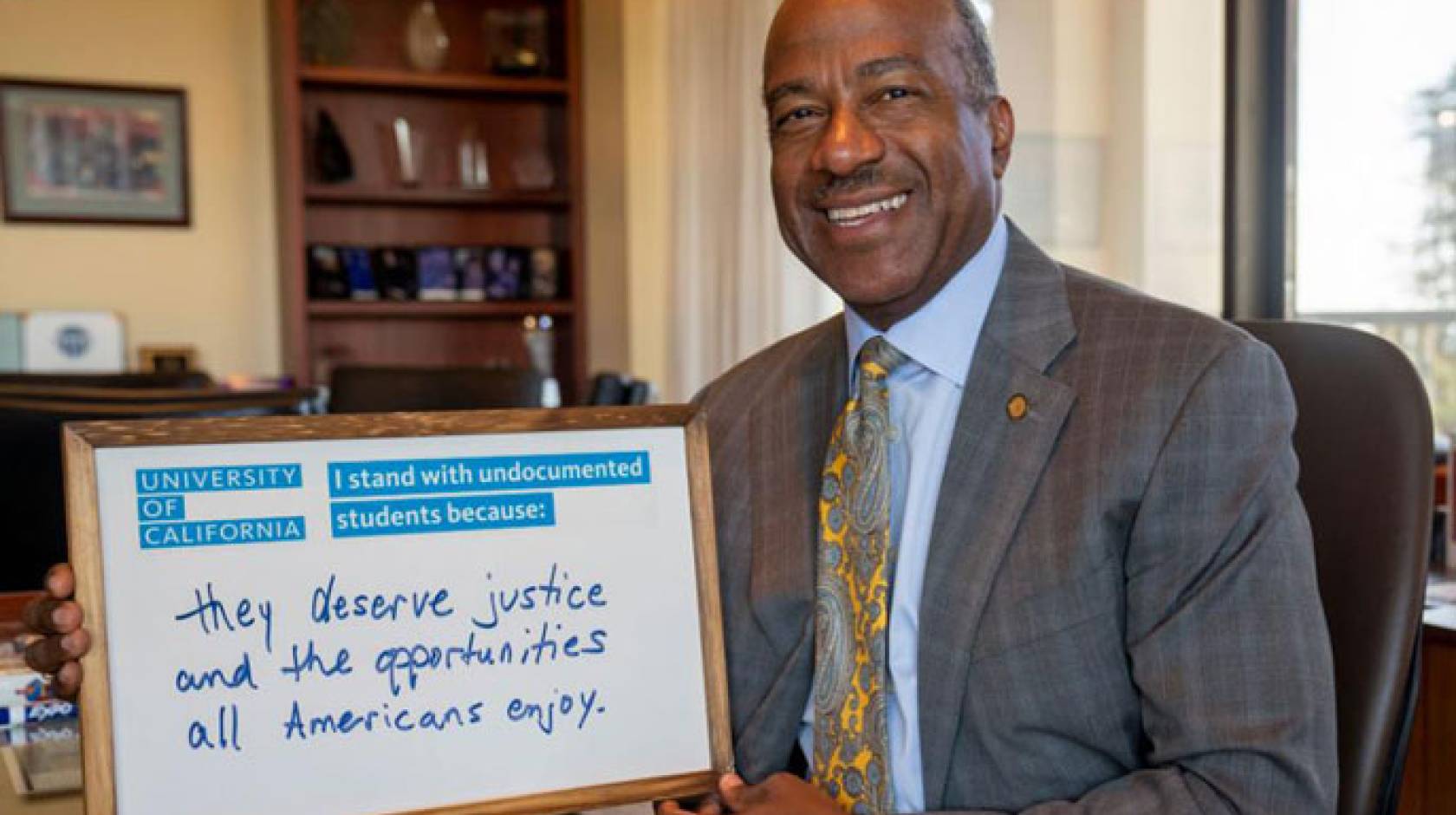 Chancellor May holds a whiteboard supporting DACA students