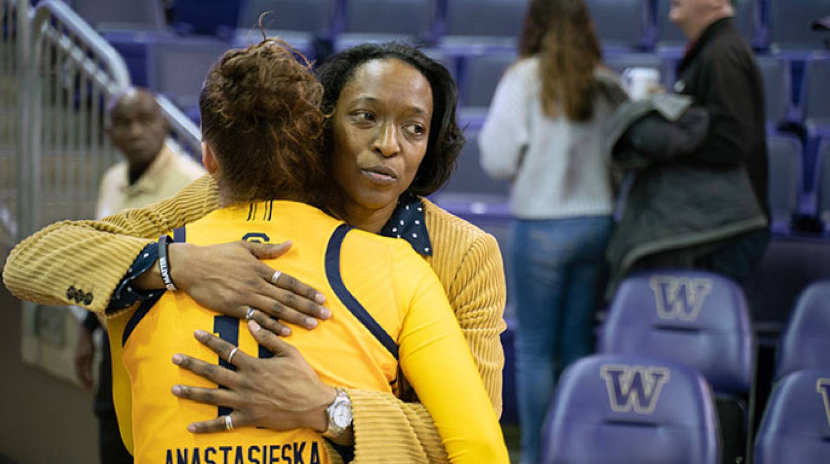 Charmin Smith consoles one of her players with a hug after a basketball game