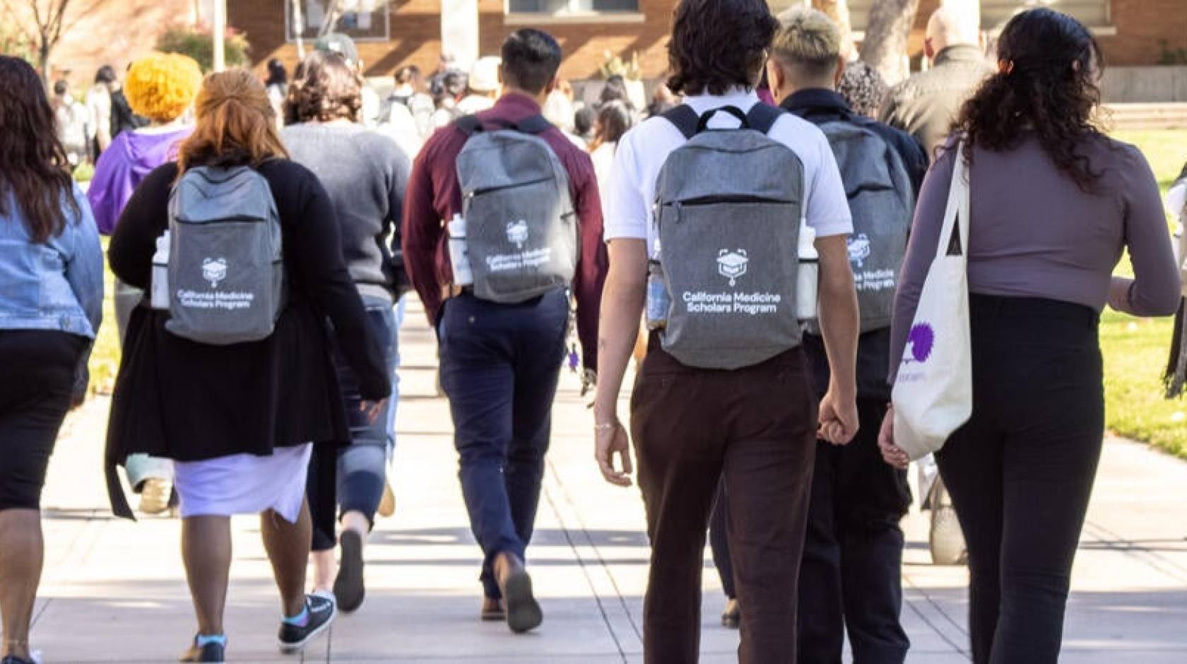 Students walking on UC Riverside campus with California Medicine Scholars Program backpacks