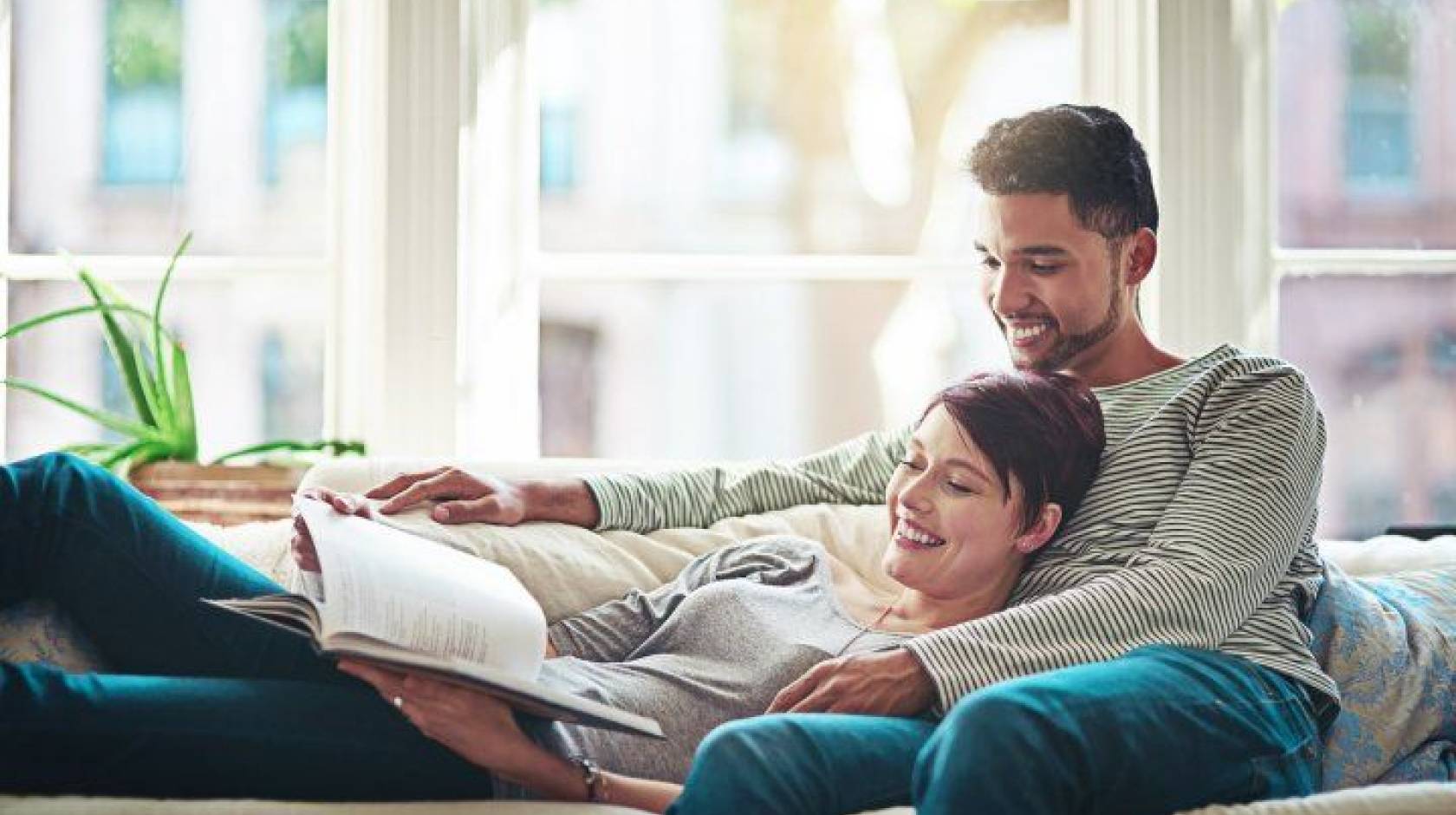 smiling couple sitting on couch