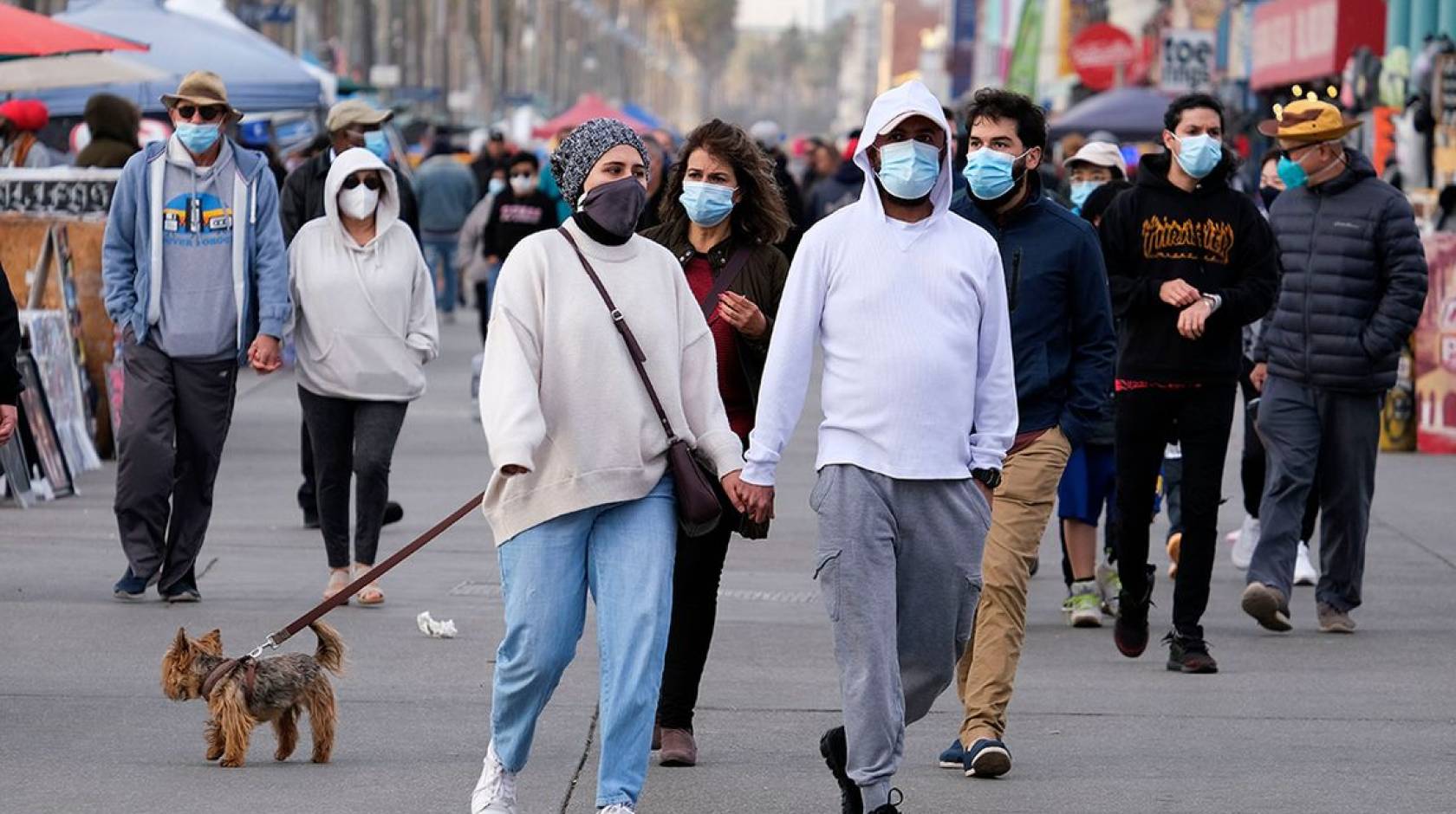 Group of people walking outside wearing masks