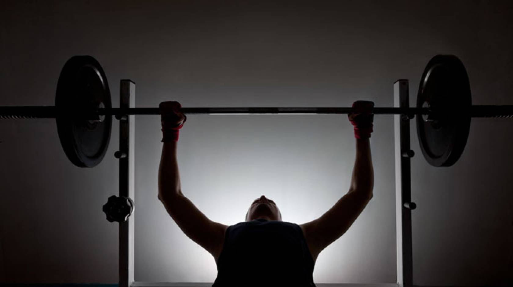 Man lifting weights in silhouette