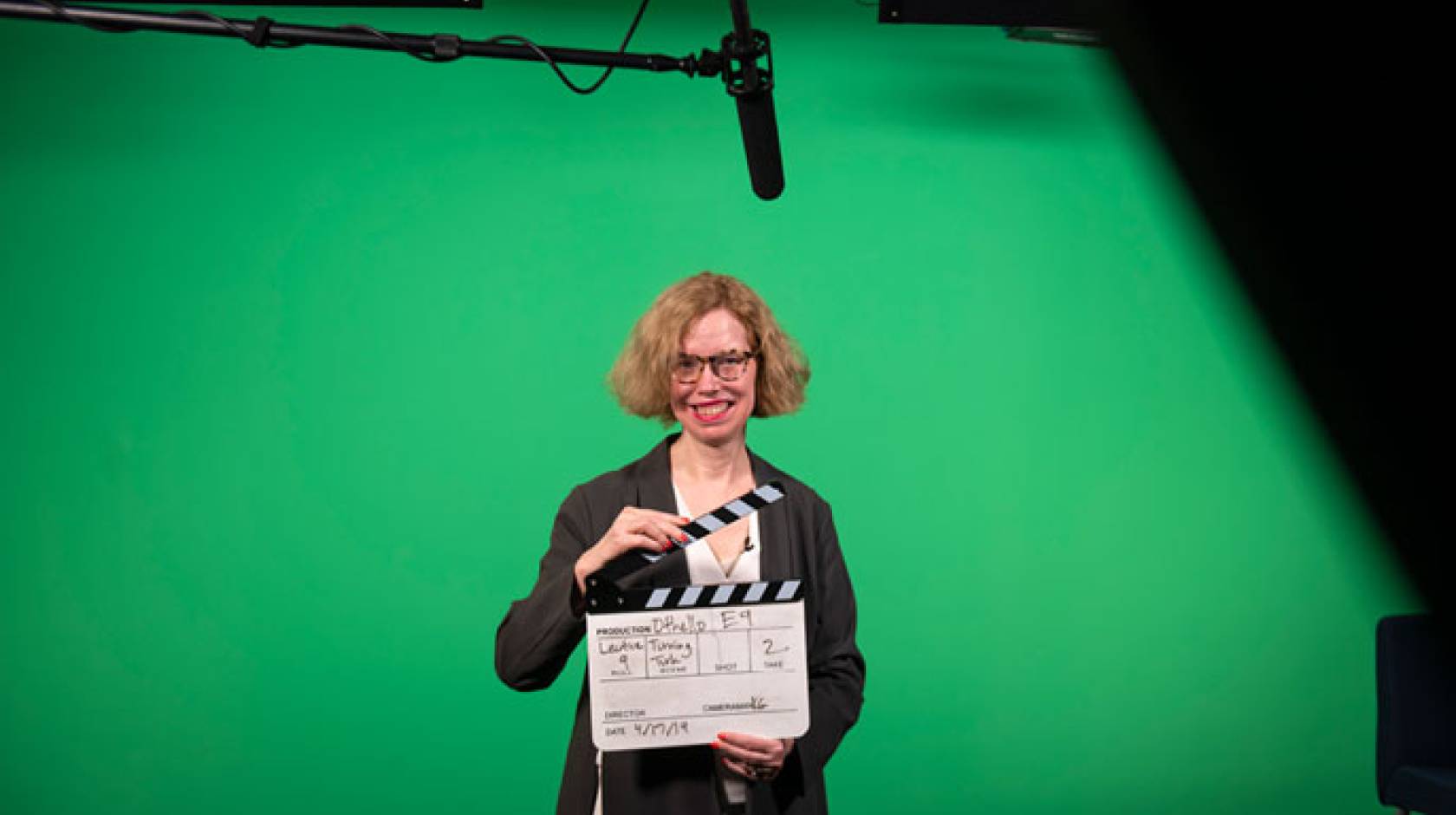 Professor holding a clapperboard