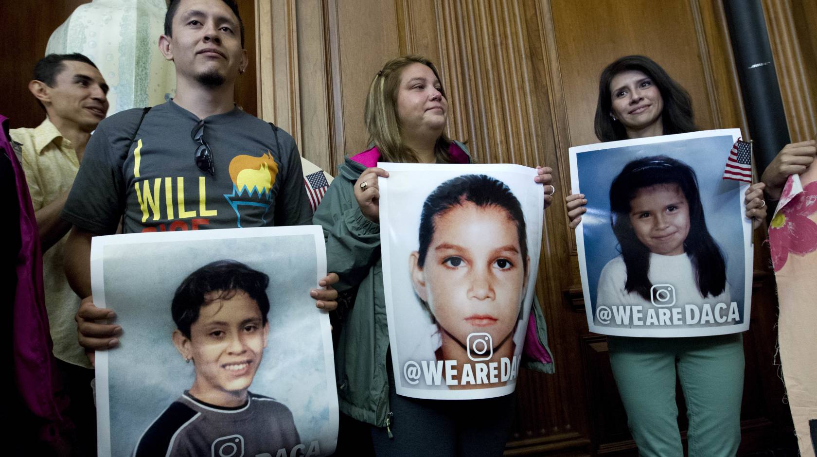 DACA recipients hold pictures of themselves as children during a Congressional meeting
