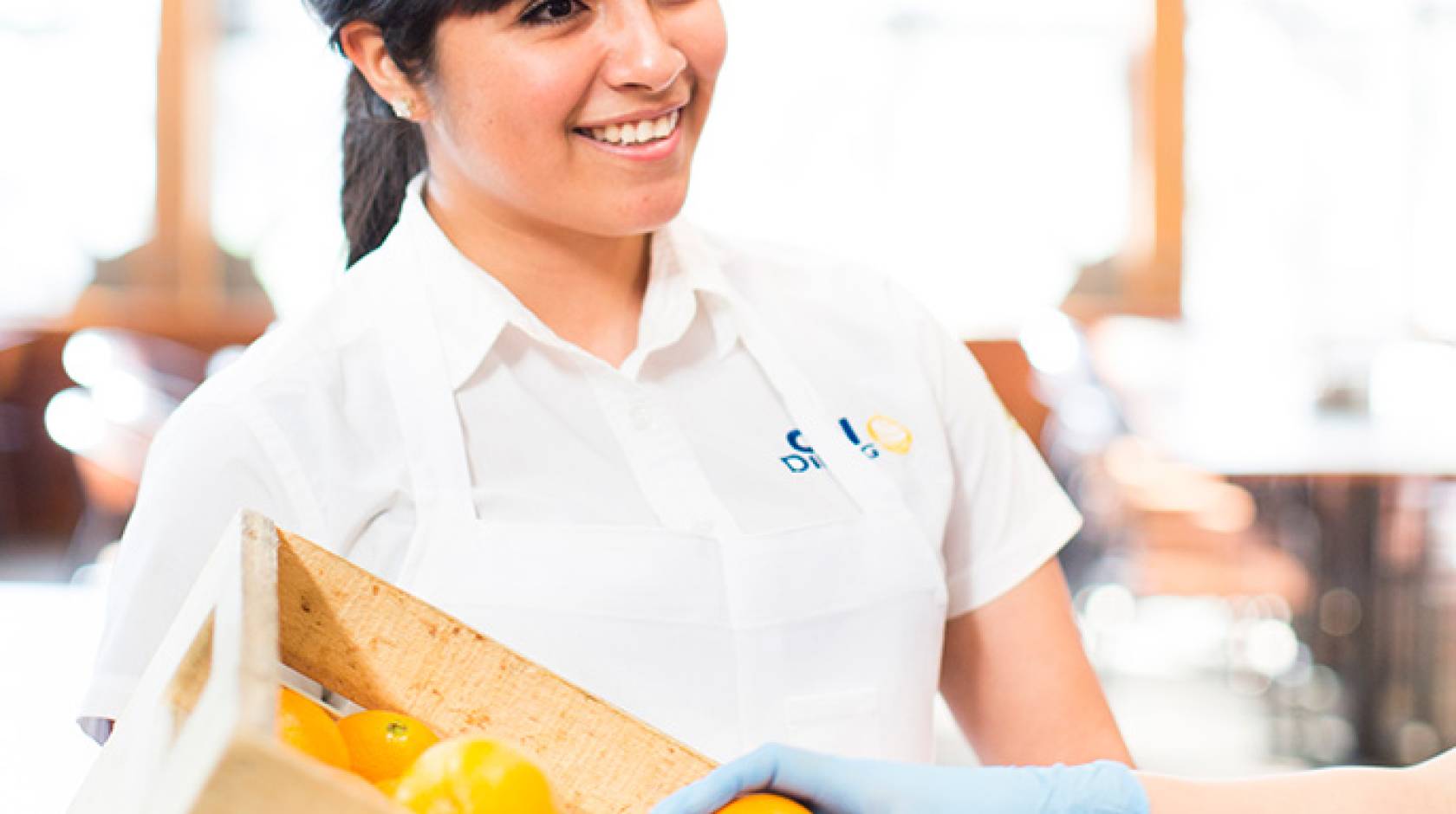 female student with crate of oranges