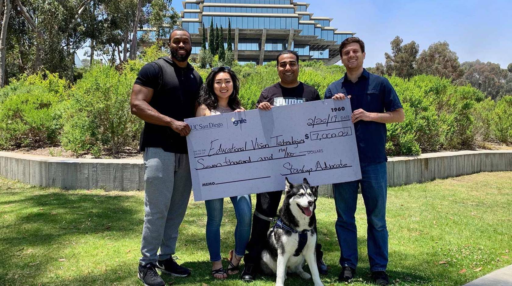 Educational Vision Technologies team members Lyn Scott, Shelly Bae and co-founders Monal Parmar and Jason Bunk hold first-place prize check after winning a pitch competition in June 2019.