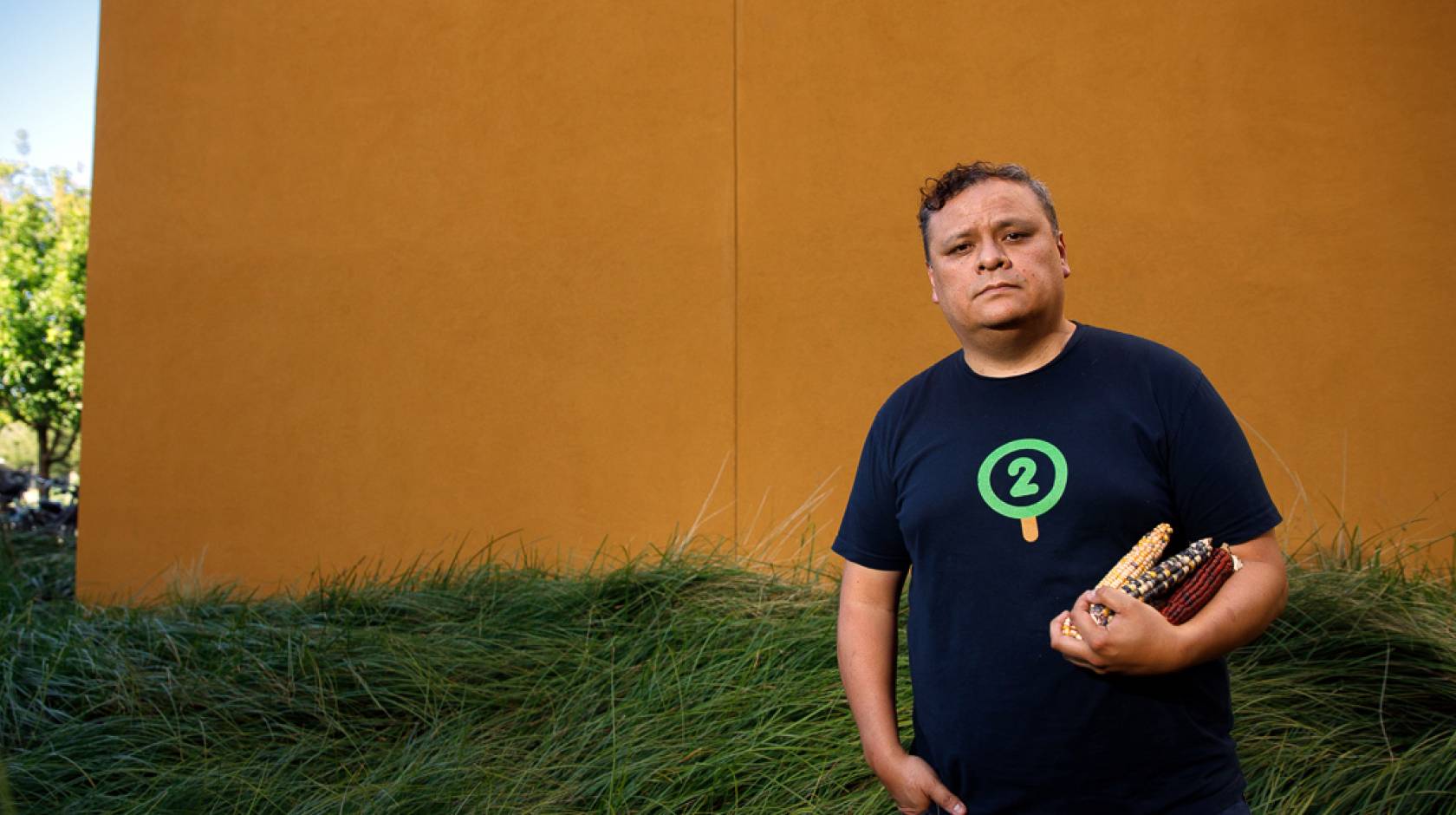 Edwin Solares outside at UC Davis holding the corn he studies