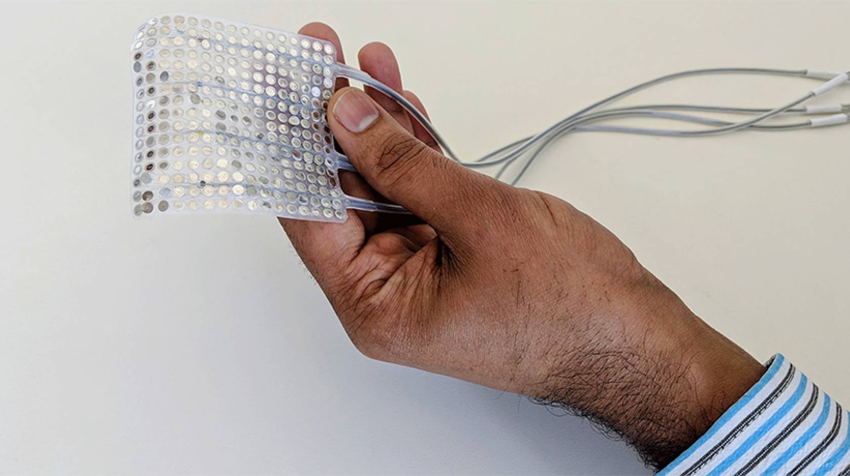 Hand holding the intracranial electrodes of the type used to record brain activity.
