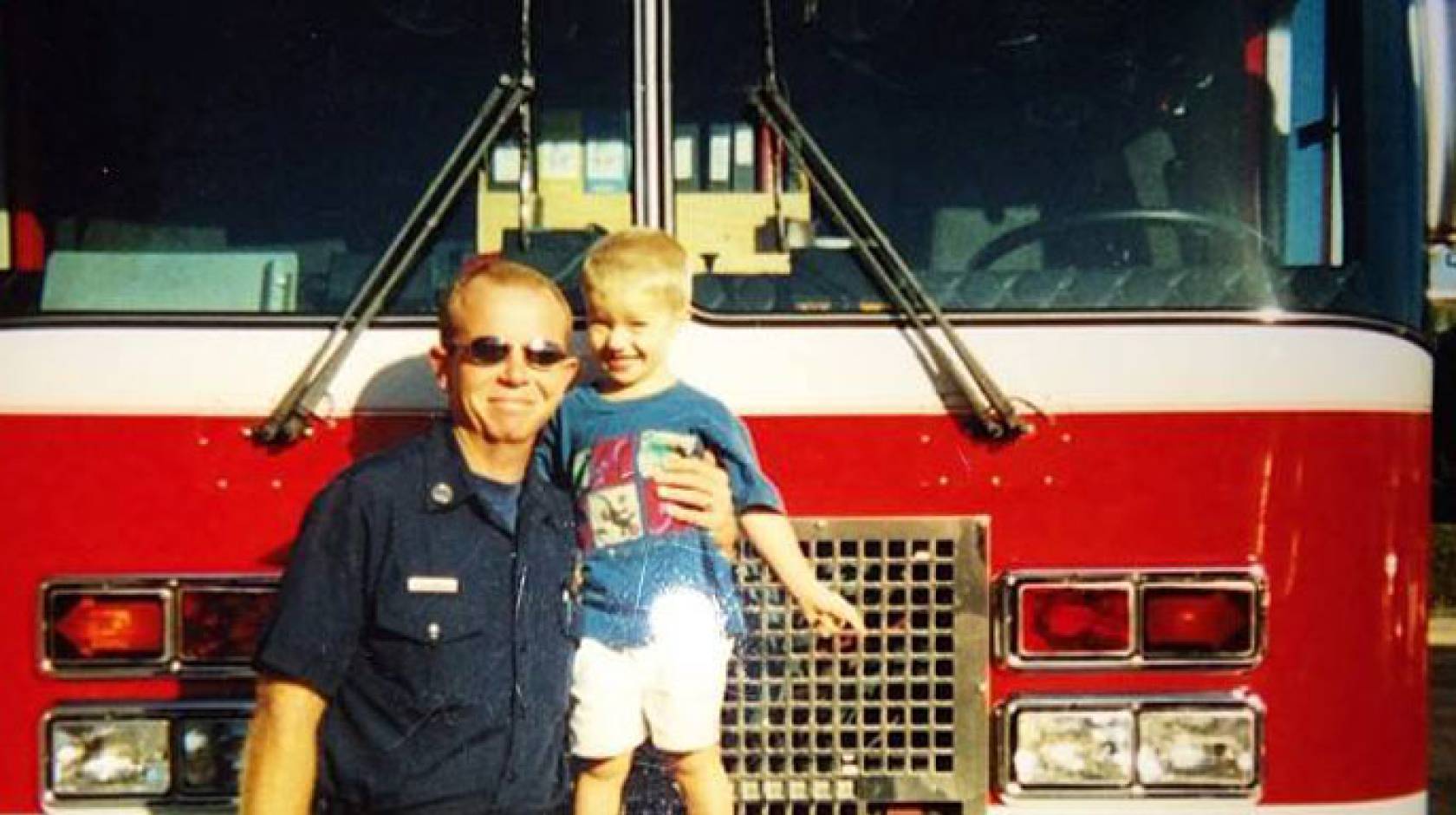 Kelly Richeson in front of fire truck with son