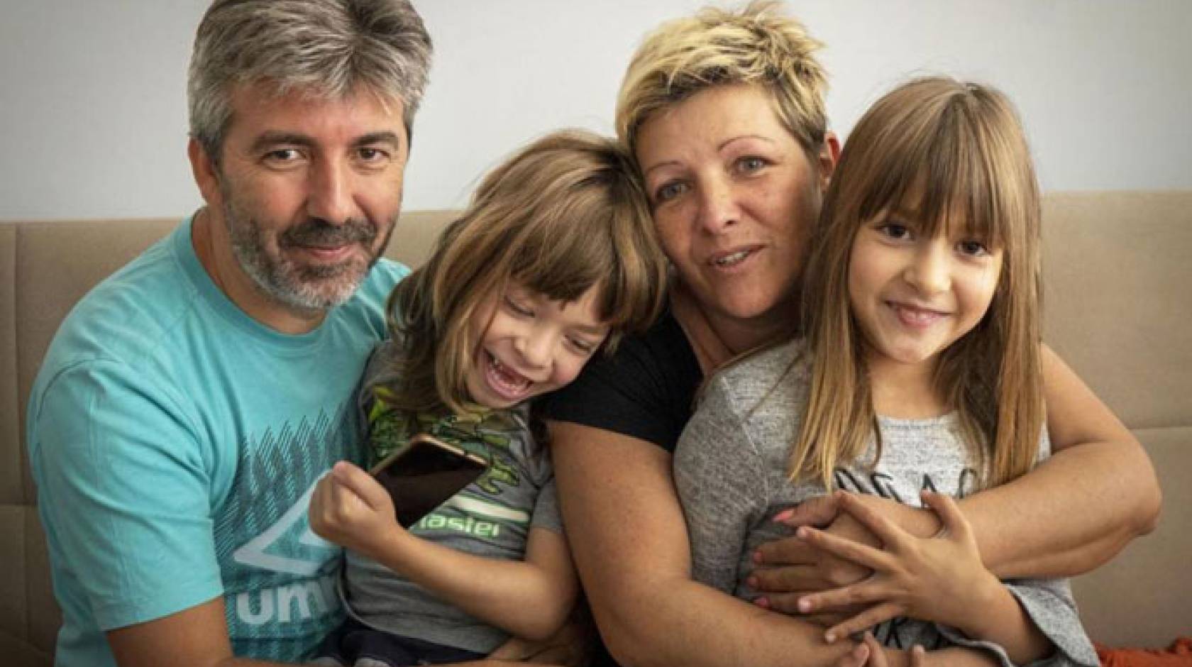 Family sits on the couch together