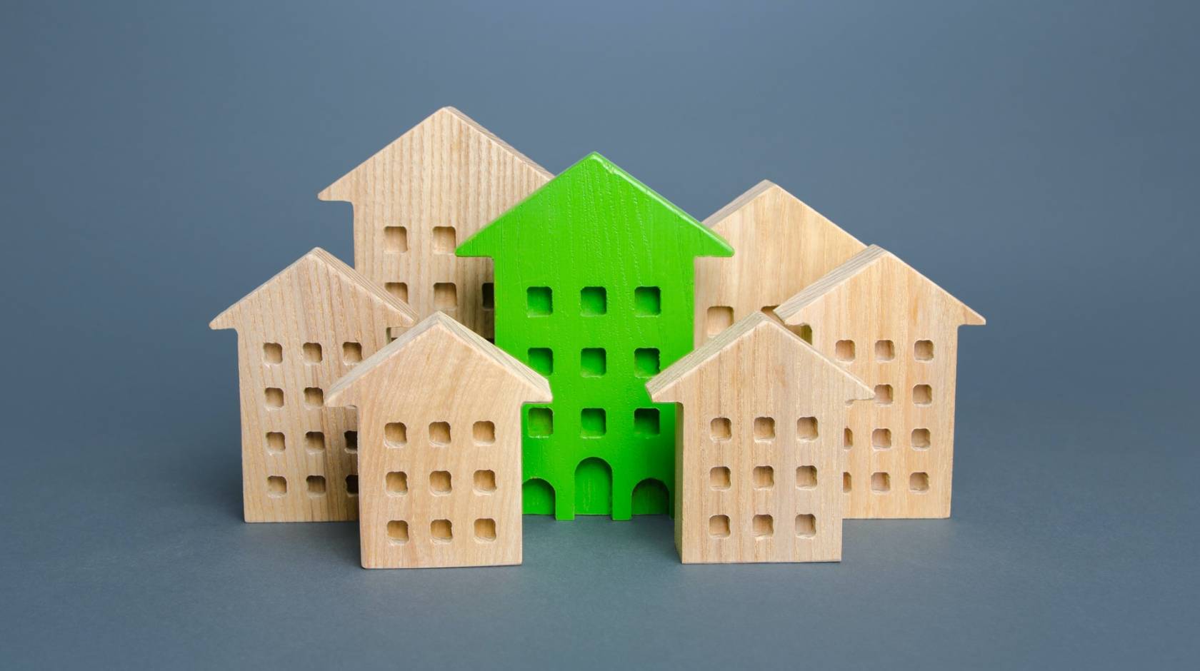 Simple wooden blocks look like buildings with a green-colored one in the middle