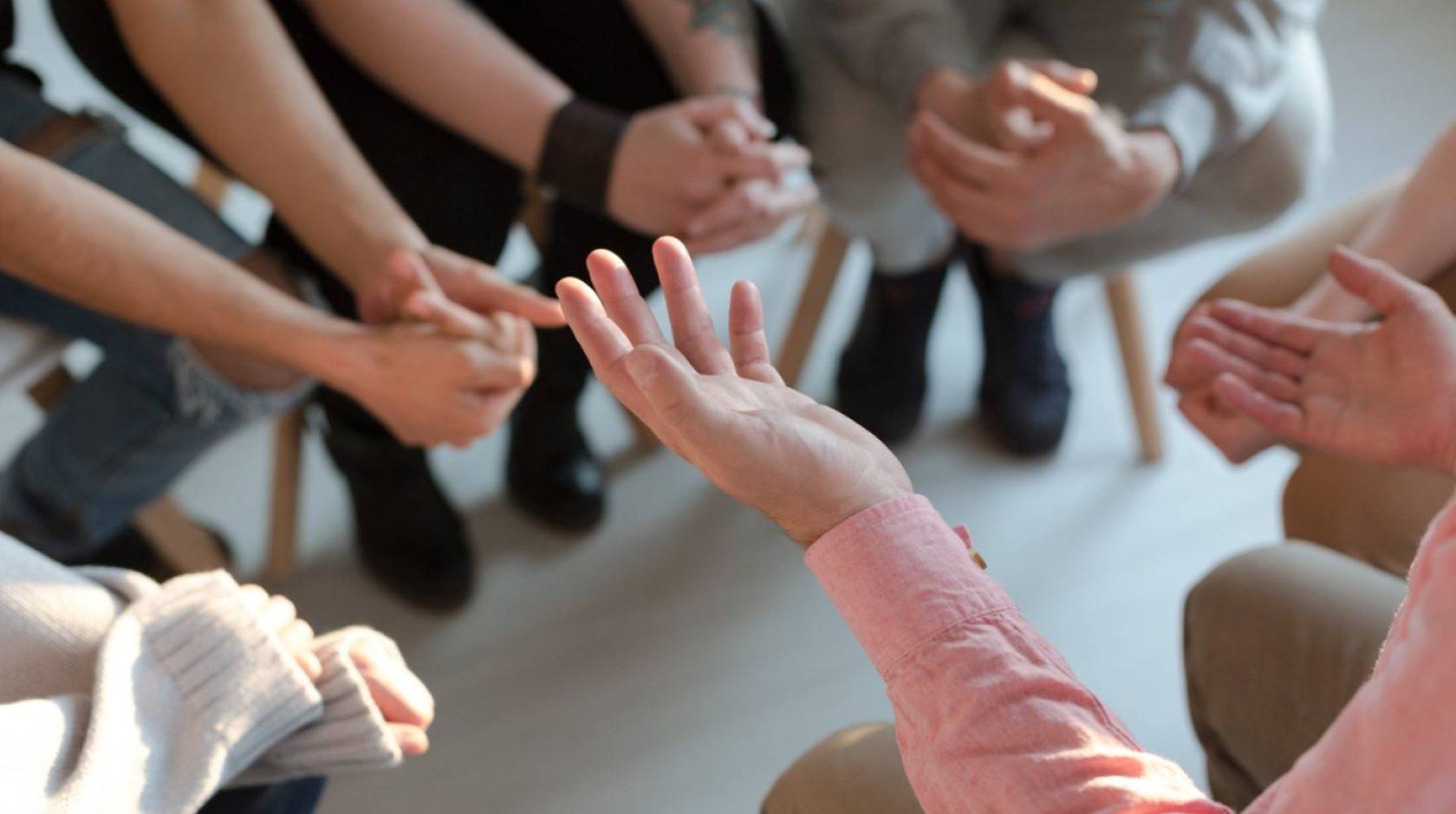 photo of hands from a group of people in discussion