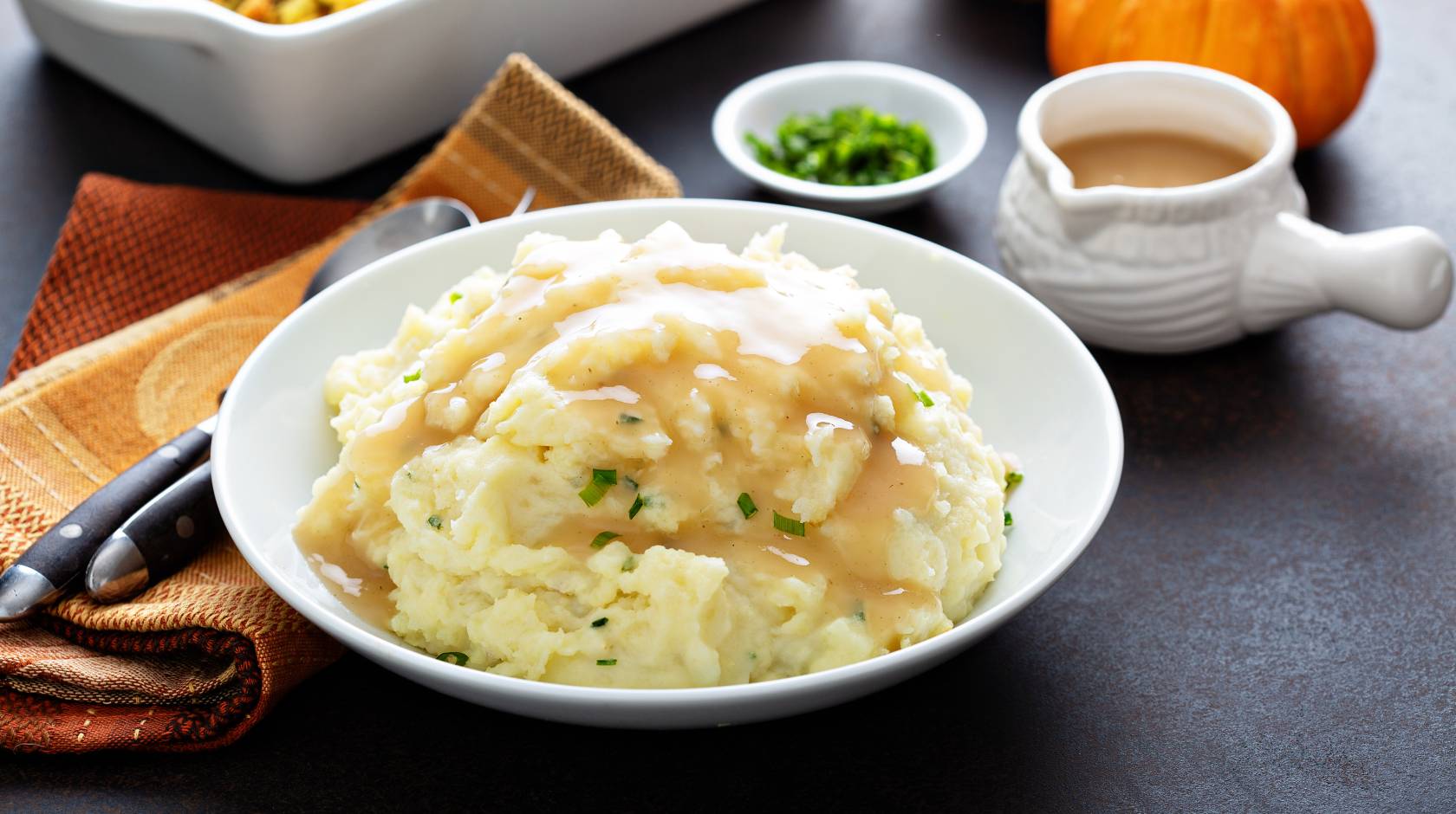 mashed potatoes, gravy and other Thanksgiving dishes on a table