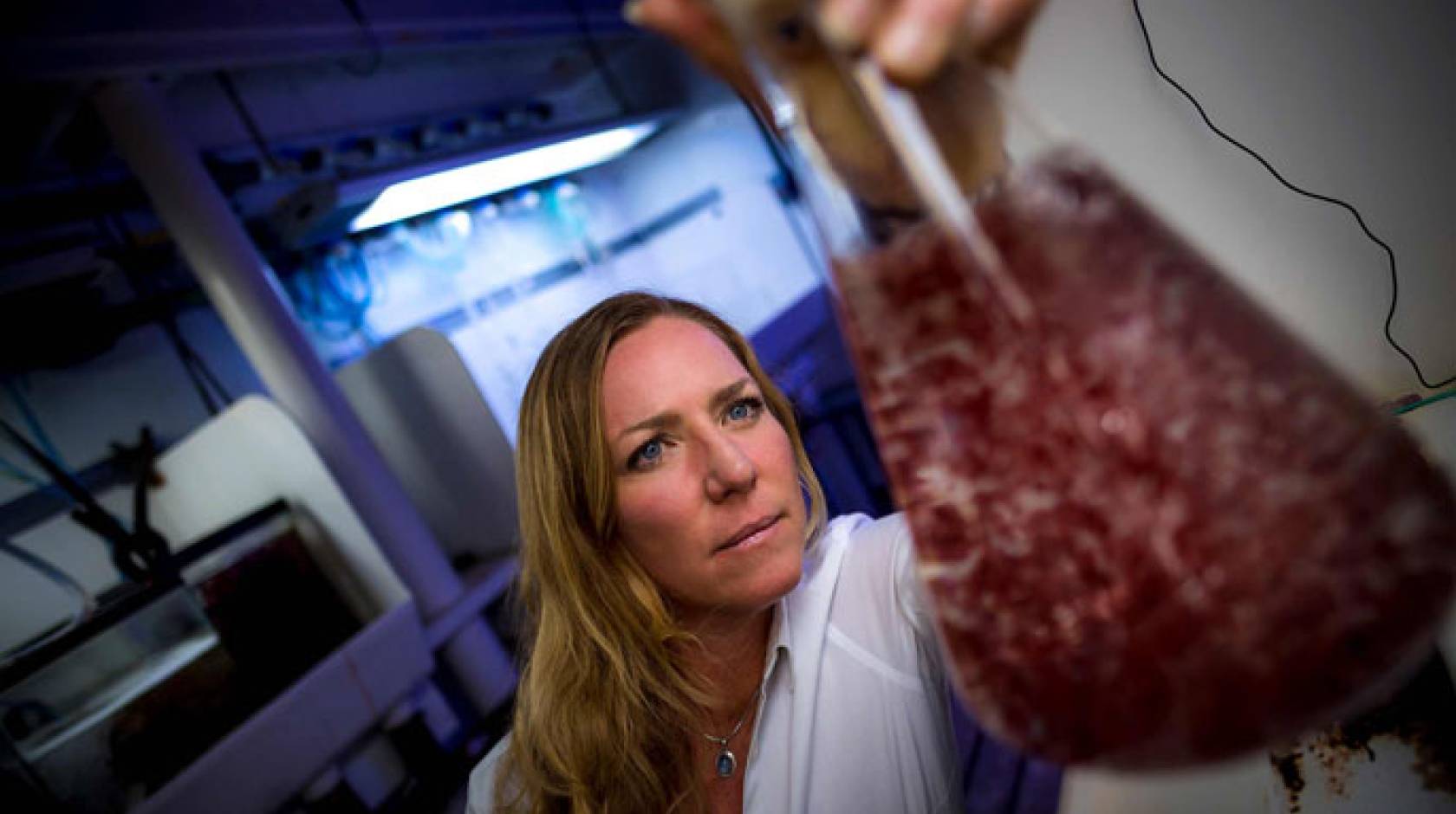 Jennifer Smith holding up a flask of seaweed