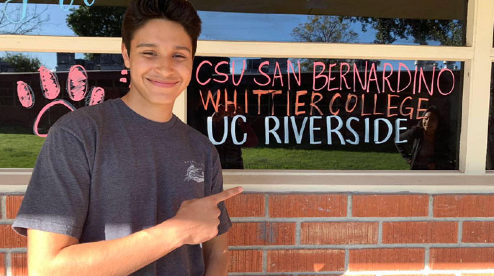 Jerry points at a window with names of colleges on it