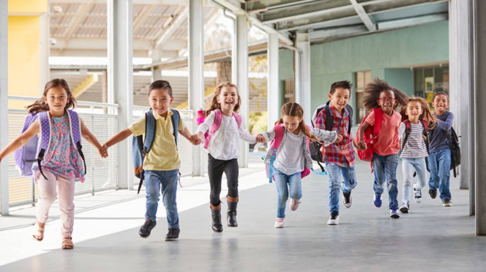 Kids run through an outdoor hallway