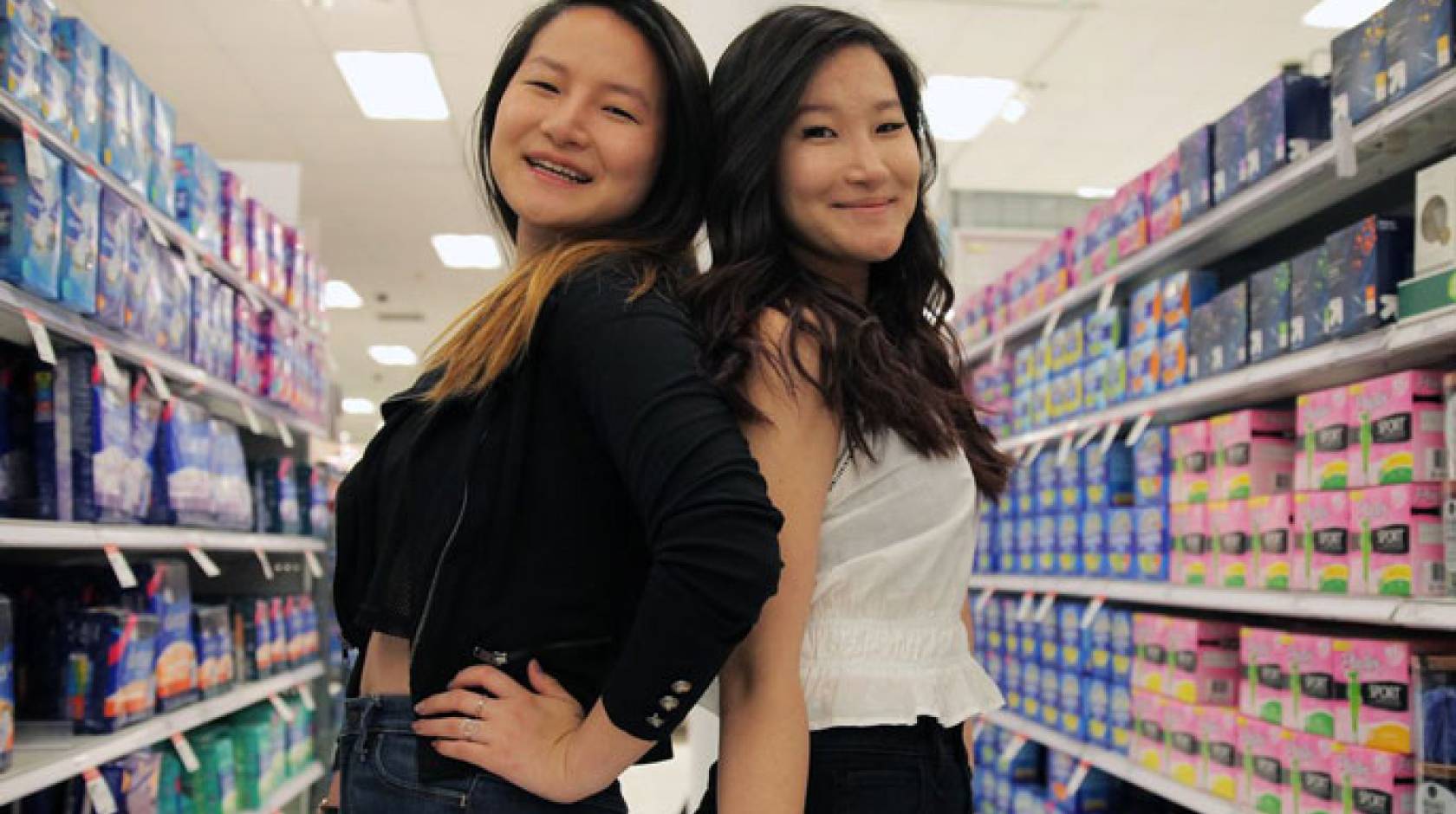 Lee sisters pose together in the feminine products aisle of a store