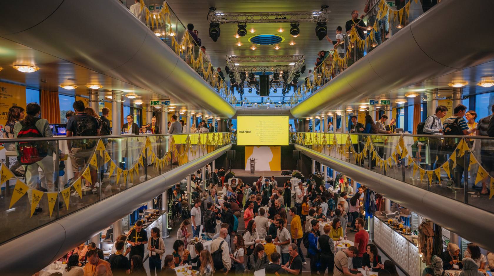 A bustling and vibrant modern hall inside a boat with several levels