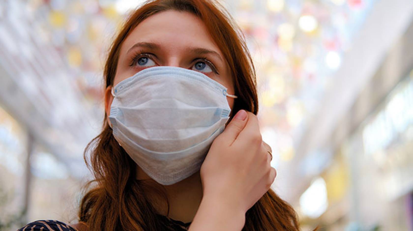 Woman thinking about taking off mask