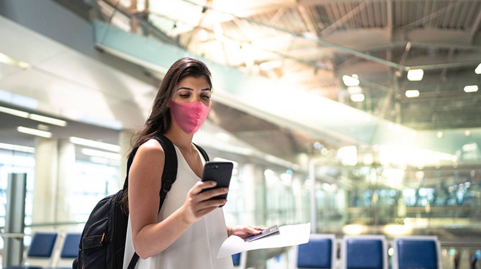 Woman at airport, checking her cell phone