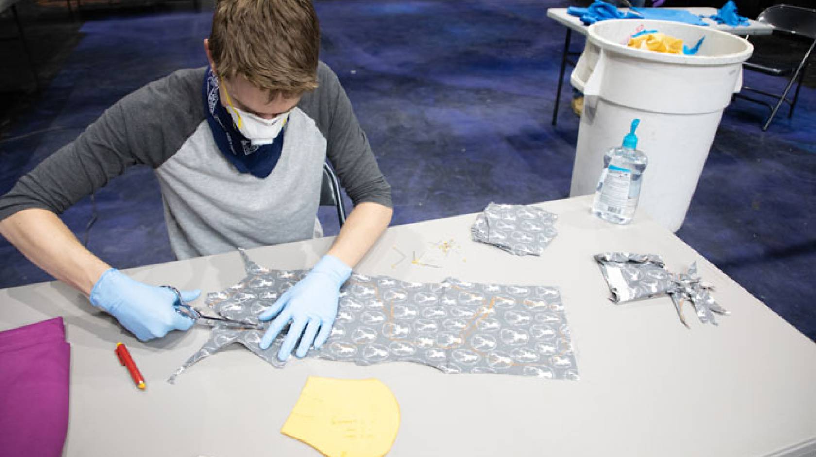 Young man sewing masks