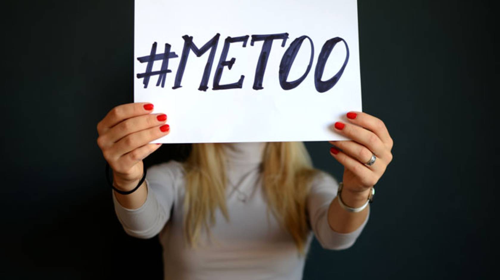 Hands holding up a #MeToo sign