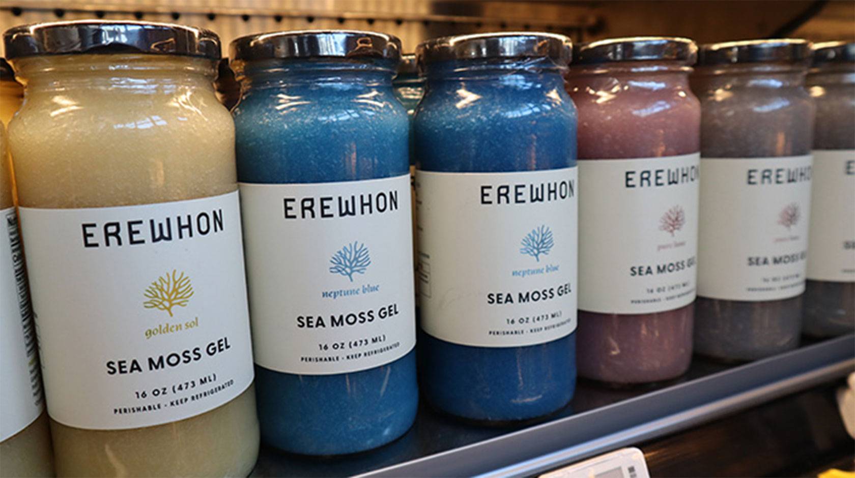 A row of jars of Erewon-brand sea moss gel in muted pastel tones