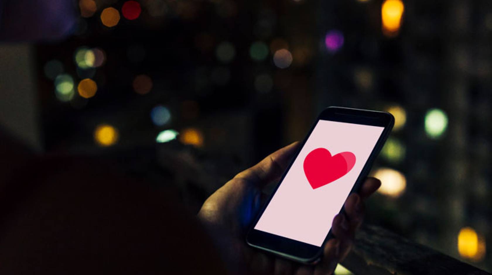 A phone with a heart on it at night