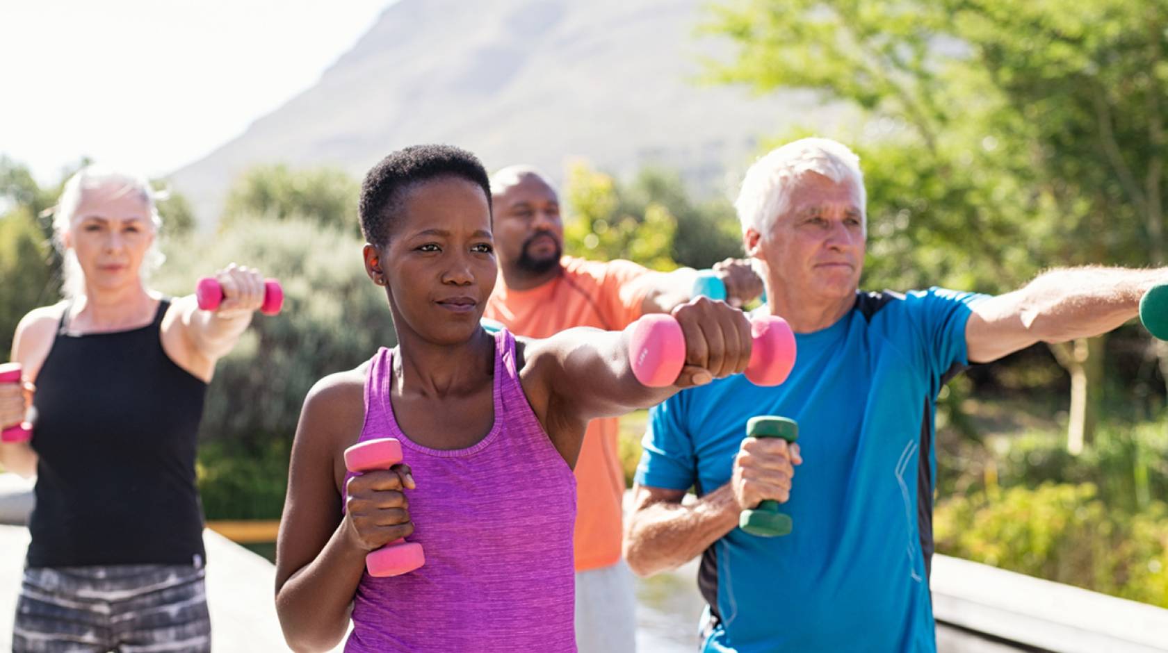 Older adults working out together with weights outdoors