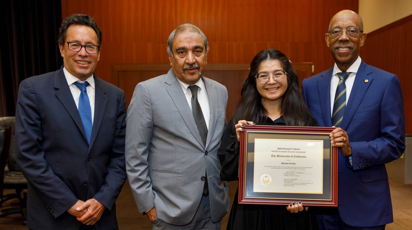 Chair Richard Leib, Chancellor Khosla, a young Latina woman Maribel Patiño, and President Drake 